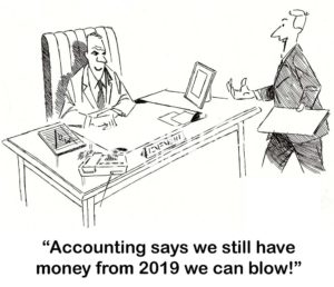B&W accounting cartoon showing a worker saying to his boss, 'Accounting says we still have money from 2019 we can blow!'.
