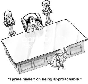 B&W boss cartoon showing a male boss sitting at his enormous desk. The boss says to a worker 'I pride myself on being approachable'.