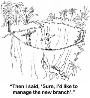 Businessman cartoon showing a two men crossing a deep divide by traversing a rope.  One says to his colleague, I said sure I would like to manage the new branch.