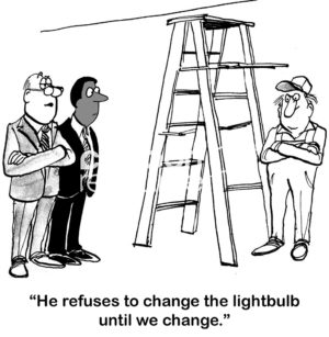 B&W change cartoon showing a janitor who has company management in a unique spot, he refuses to change the lightbulb until they change.