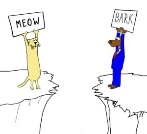 Color conflict cartoon showing a worker dog and a worker cat each on a cliff. The holds a sign saying "bark" and the cat's says "meow".