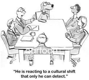 B&W marketing cartoon showing a business meeting with business dog listening intently.  The male boss explains business dog is detecting "... a cultural shift that only dogs can hear".
