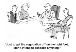 Negotiation cartoon showing a meeting.  The man at the head of the table states, "just to get the negotiation off on the right foot, I do not intend to concede anything".