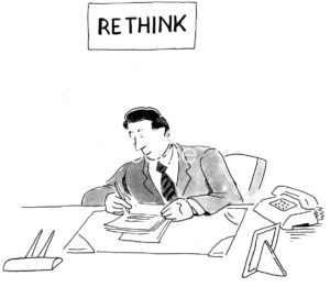Office B&W cartoon of a man at a desk. Above his head is a sign 'Re Think'.