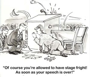 Speaking cartoon showing a speaker with crippling stage fright.  The audience is reacting negatively and his co-presenter tells him he can have stage fright 'as soon as your speech is over!'.