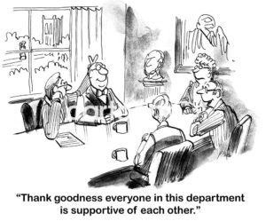 B&W cartoon of five workers at a meeting table. One is playing a trick behind another's back as a third states, 'thank goodness everyone in this department is supportive of each other'.