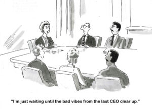 BW cartoon of a female CEO in a meeting and stating she is waiting for the old CEO's bad vibes to go away.